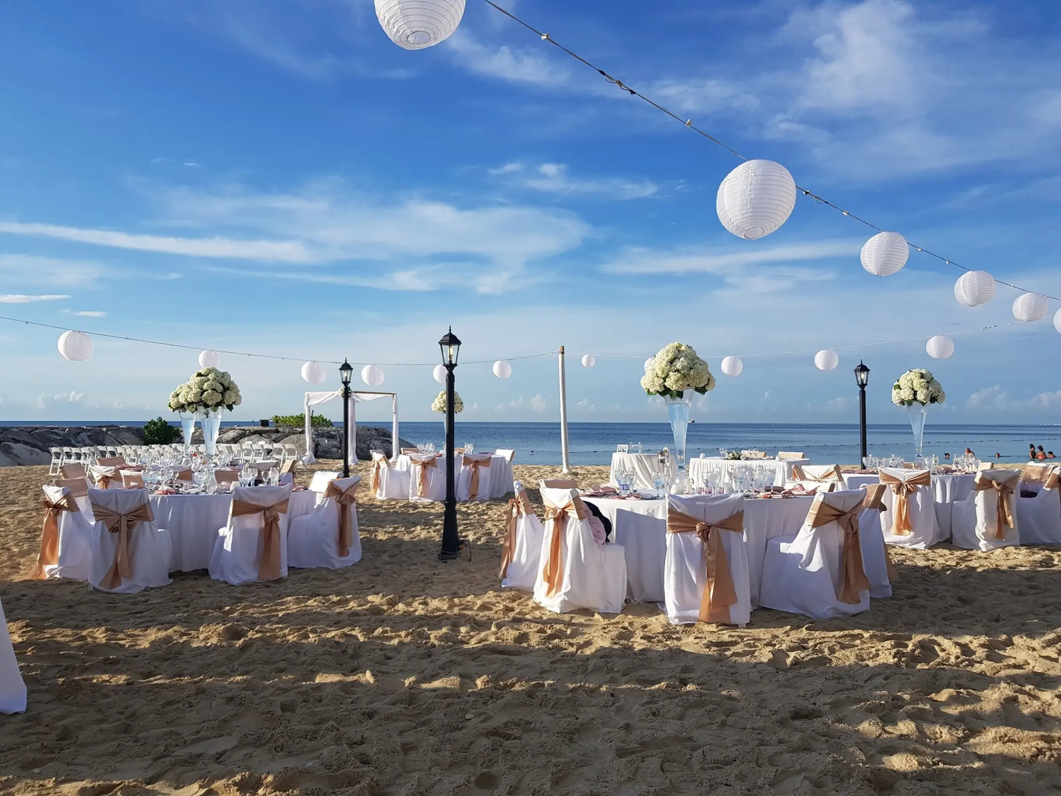 Beach wedding reception with white lanterns and floral centerpieces at Breathless Montego Bay