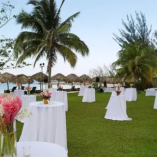 Outdoor wedding reception setup with cocktail tables on a lawn at Breathless Montego Bay, Jamaica