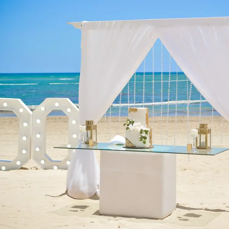 Beachfront wedding setup with cake and I DO letters at Breathless Punta Cana