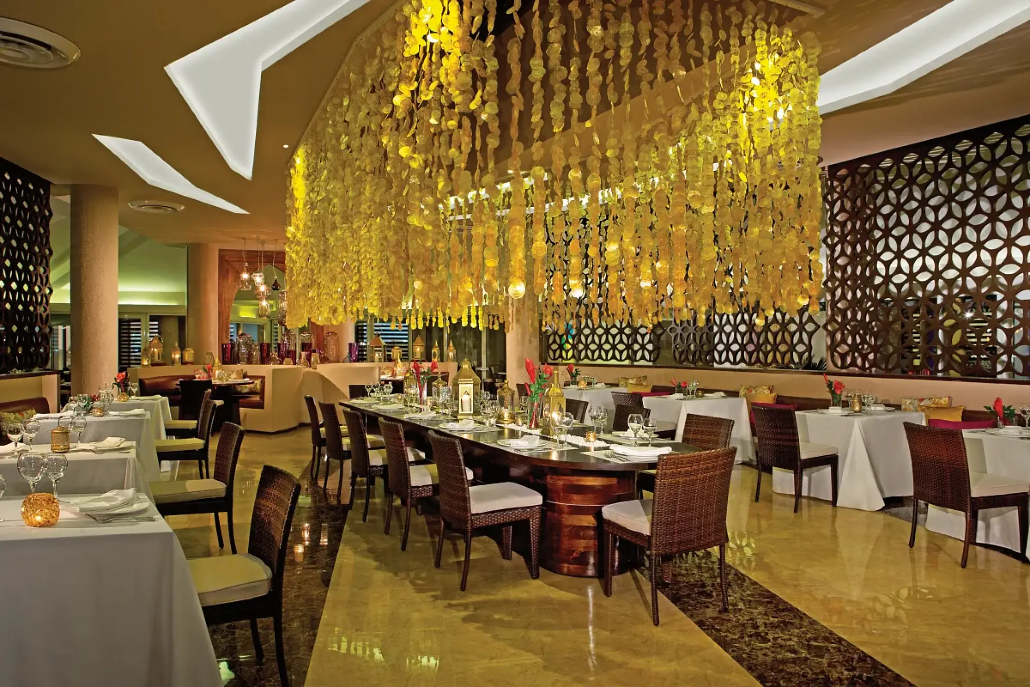 Kibbeh restaurant interior with decorative hanging lights and set tables at Breathless Punta Cana