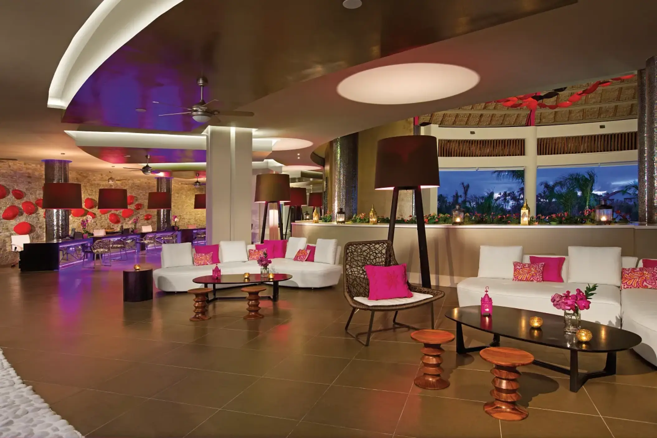 Modern open-air lobby with pink accents and lounge seating at Breathless Punta Cana