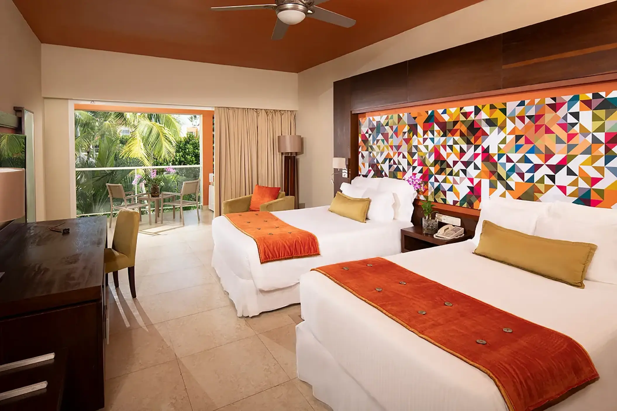 Modern suite with two beds and a colorful geometric headboard at Breathless Punta Cana