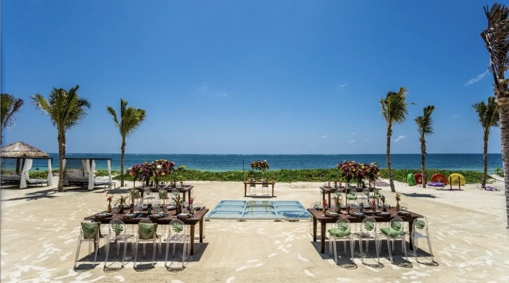 Beachfront wedding reception with wooden tables and glass dance floor at Breathless Riviera Cancun, Riviera Maya