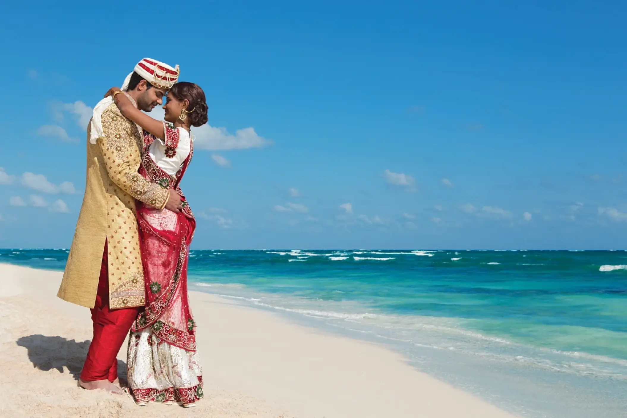 Hindu wedding couple embracing on the shore at Dreams Macao Beach, Punta Cana