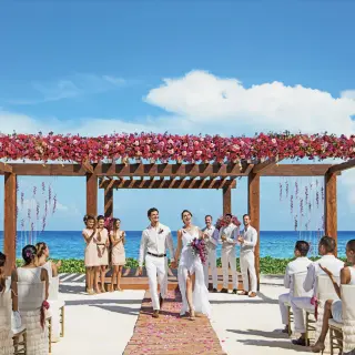 Bride and groom walking down the aisle at a beach wedding ceremony at Breathless Riviera Cancun, Riviera Maya