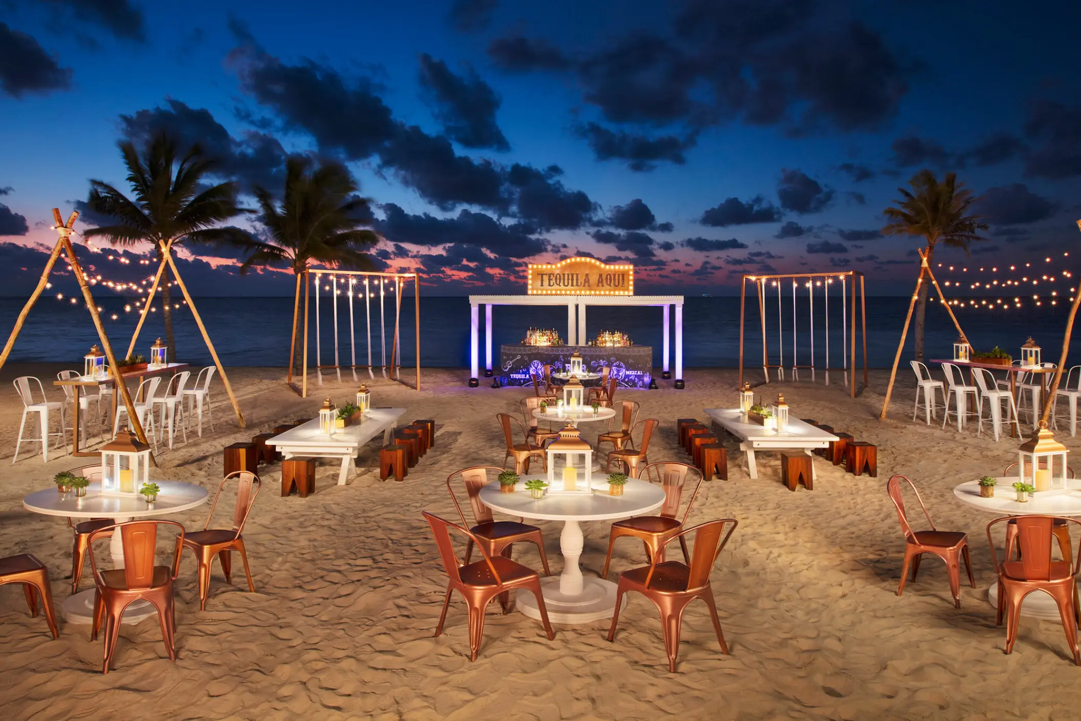 Nighttime beach wedding reception with string lights and white tables at Breathless Riviera Cancun, Riviera Maya