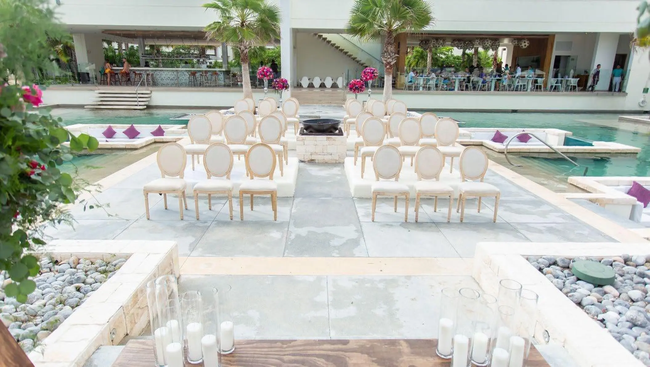 Outdoor wedding ceremony setup with white chairs on a platform over the pool at Breathless Riviera Cancun, Riviera Maya