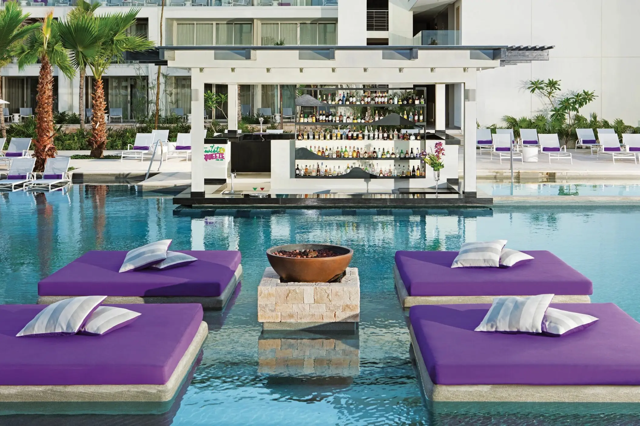 Purple floating daybeds and swim-up bar at Breathless Riviera Cancun, Riviera Maya