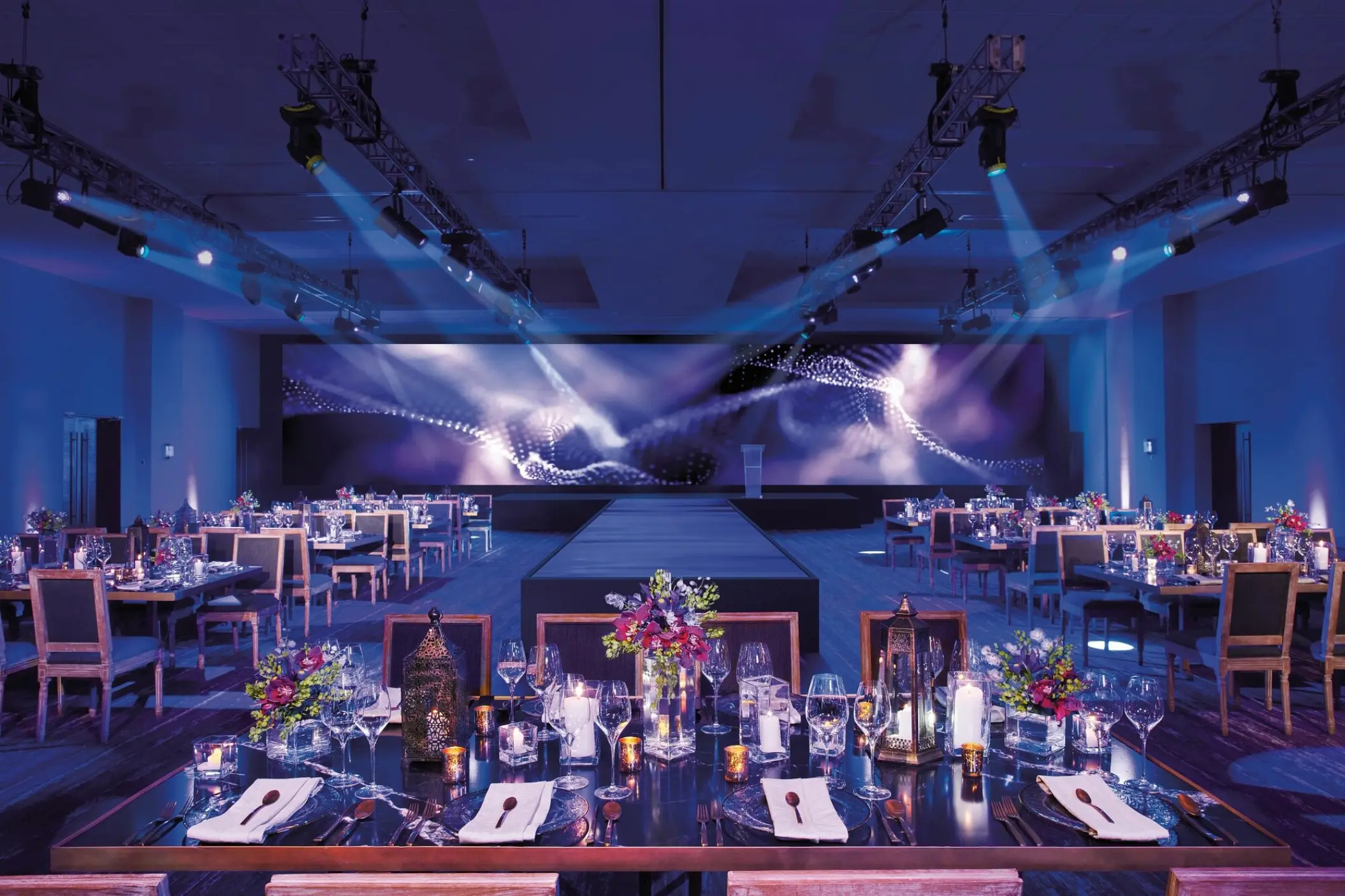 Indoor wedding reception with blue spotlighting in the ballroom at Breathless Riviera Cancun, Riviera Maya
