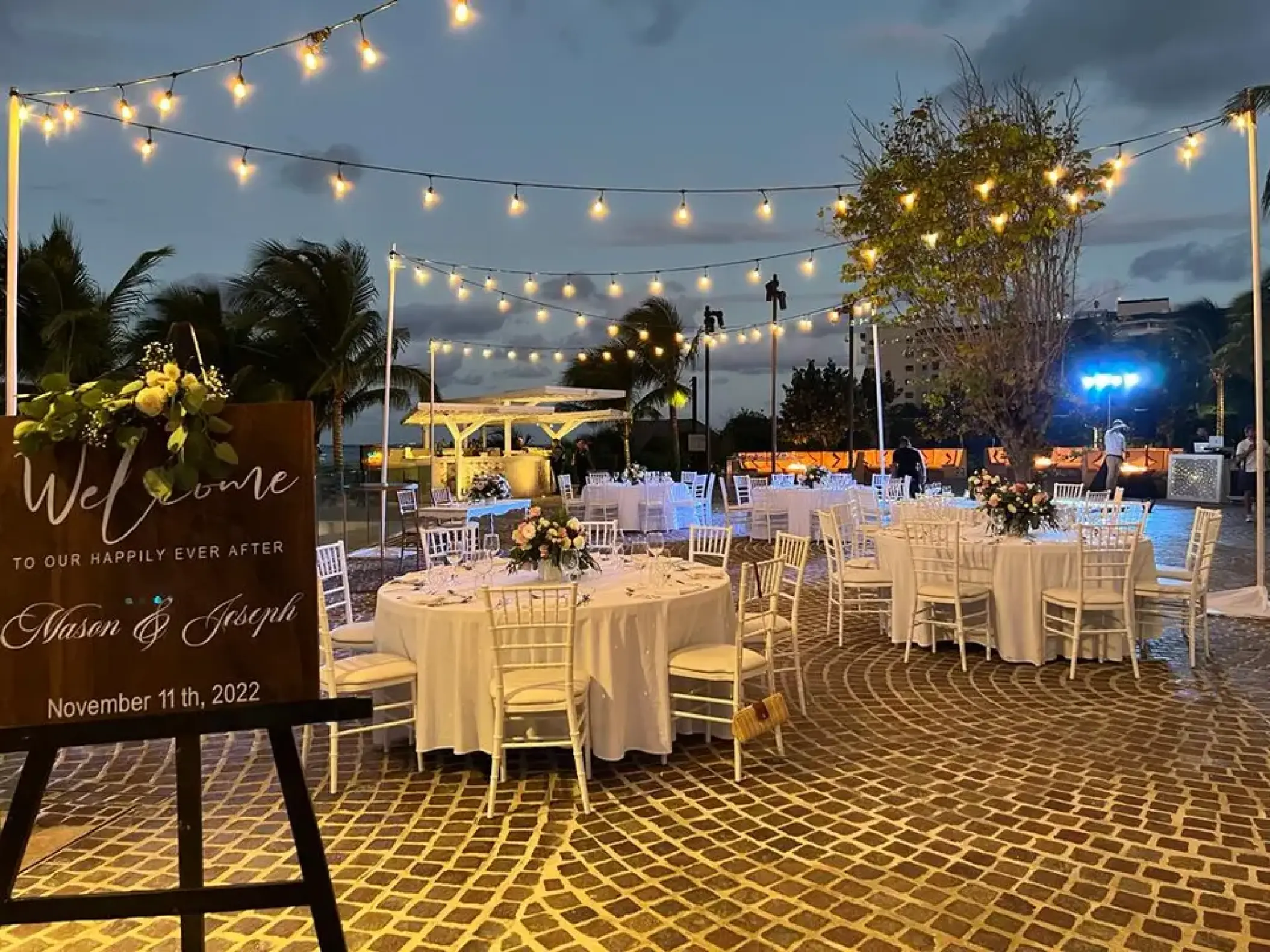 Outdoor wedding reception with string lights and white table settings at Breathless Cancun Soul, Cancun