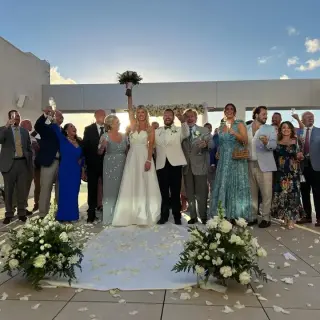 The couple and their guests cheering at a rooftop wedding ceremony at Breathless Cancun Soul, Cancun
