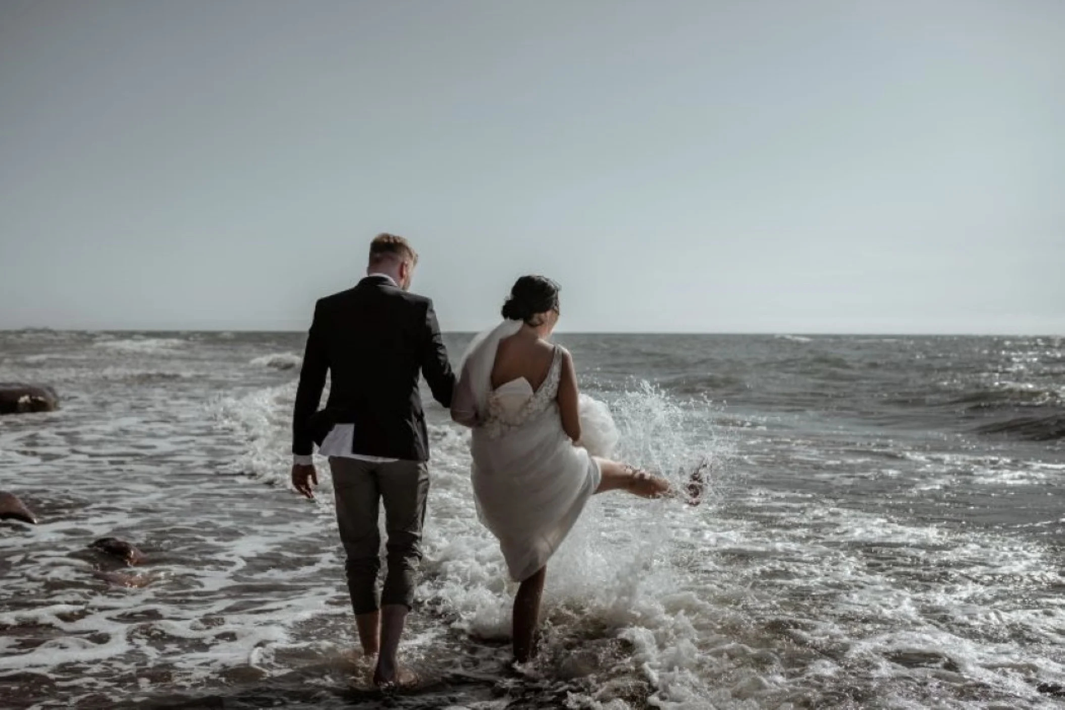 bride and groom playing in the sea