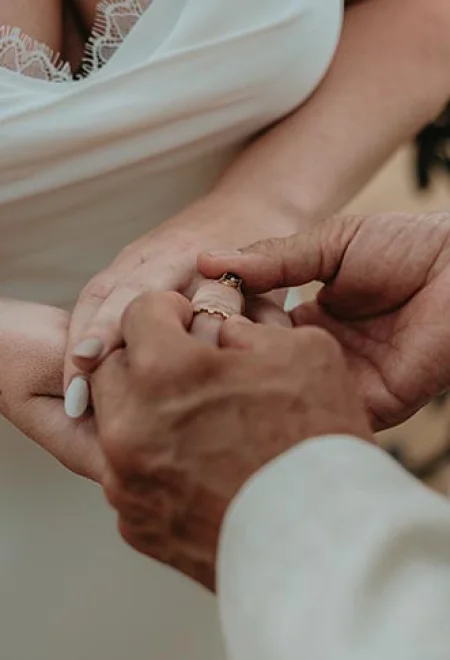 groom put the wedding band on his bride's finger