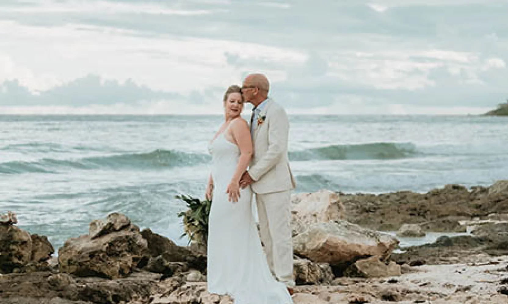groom and bride at rocky beach