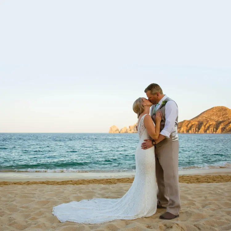 The bride and groom kissing on the beach at Casa Dorada, Cabo San Lucas