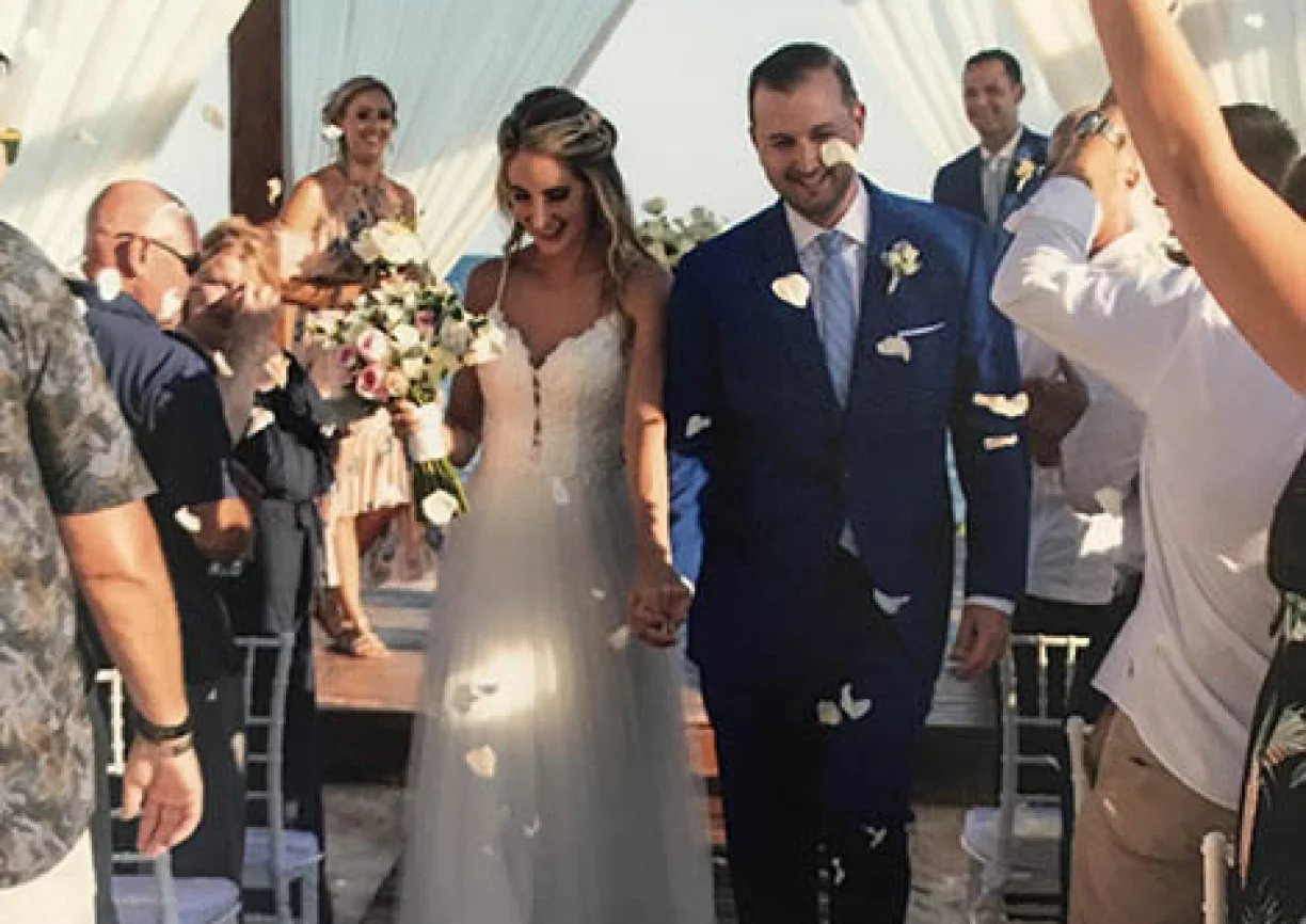 Groom and bride walking out of the isle in the middle of a flower petal rain