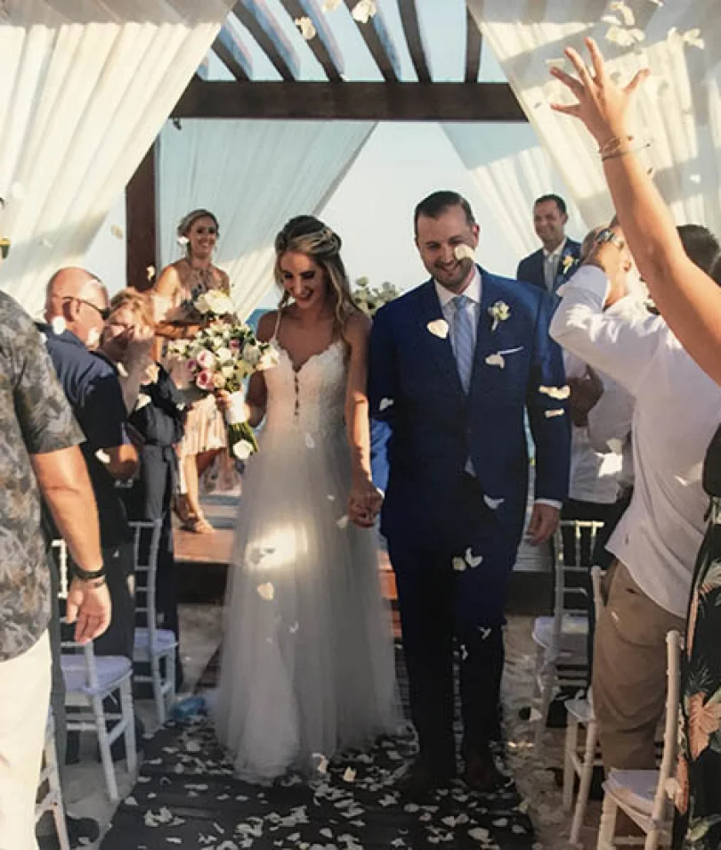 Groom and bride walking out of the isle in the middle of a flower petal rain