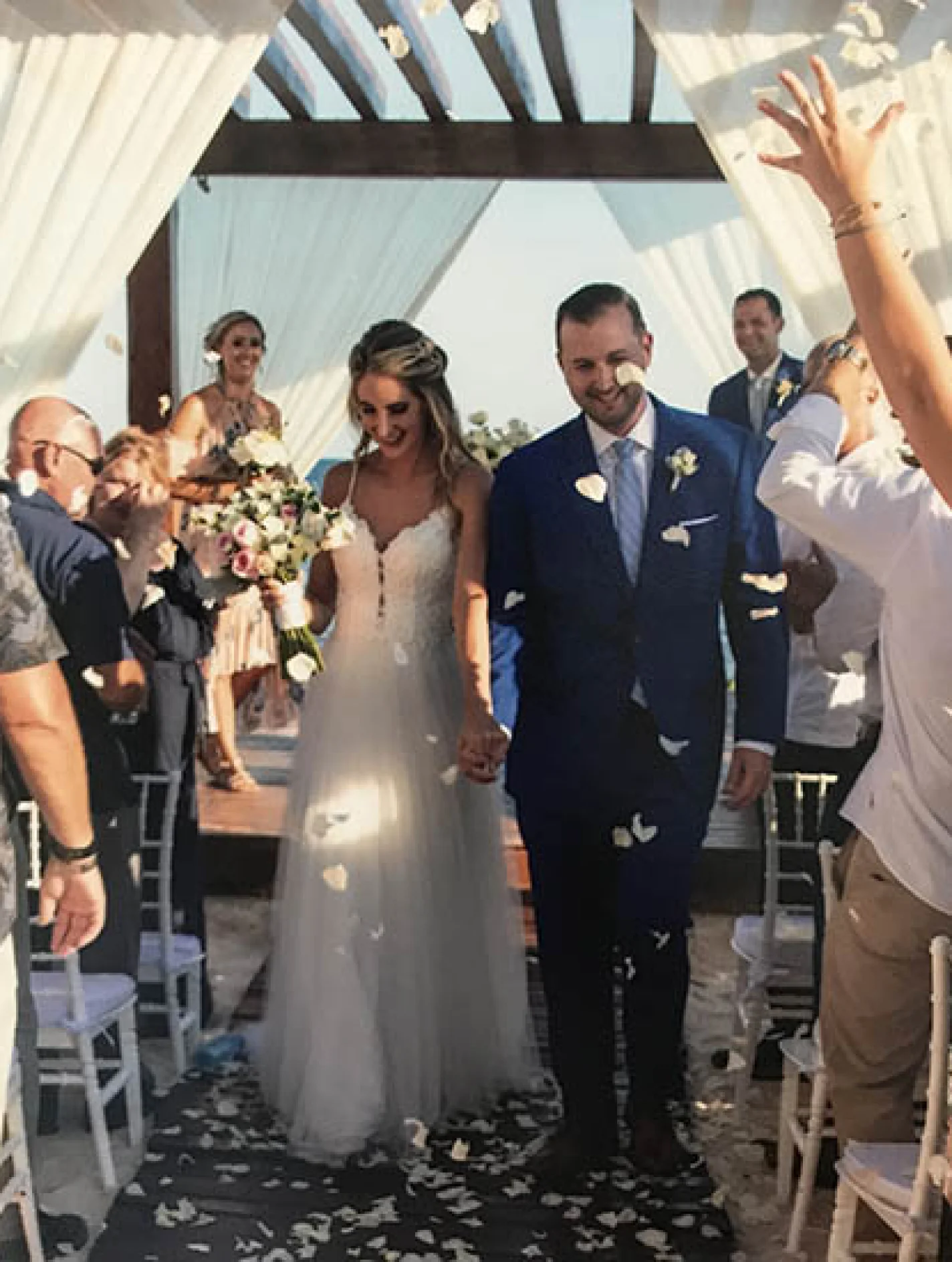 Groom and bride walking out of the isle in the middle of a flower petal rain