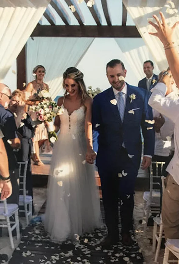 Groom and bride walking out of the isle in the middle of a flower petal rain