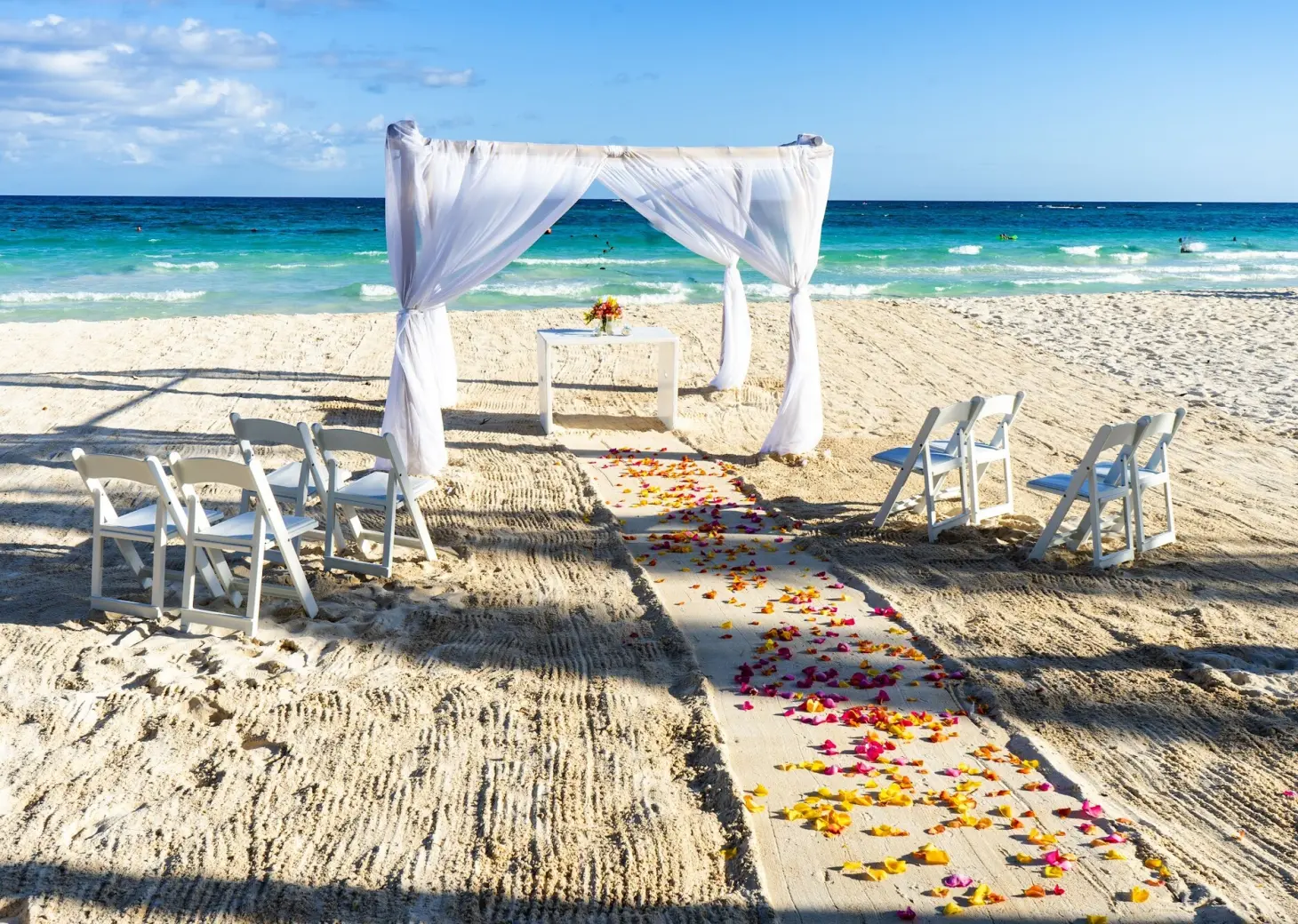Beachfront wedding ceremony with white gazebo and petal-strewn aisle at Catalonia Grand Costa Mujeres, Cancun