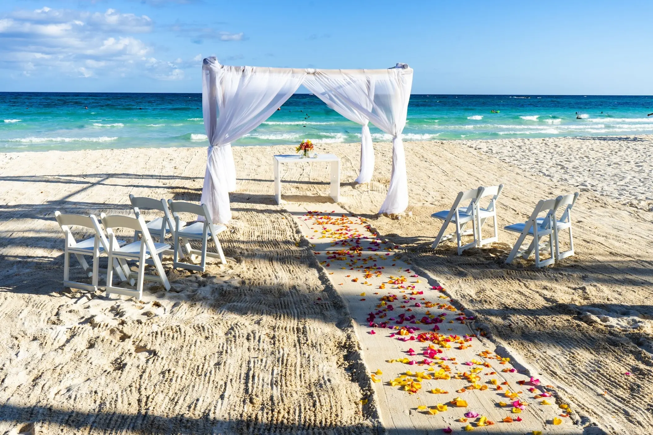 Beachfront wedding ceremony with white gazebo and petal-strewn aisle at Catalonia Grand Costa Mujeres, Cancun