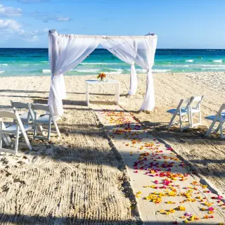 Beachfront wedding ceremony with white gazebo and petal-strewn aisle at Catalonia Grand Costa Mujeres, Cancun