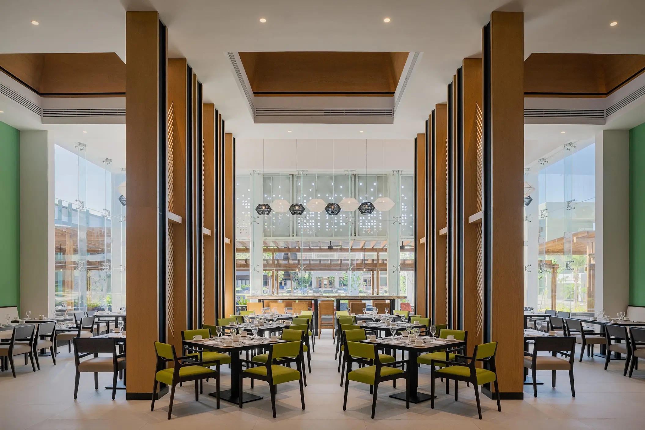 Modern buffet restaurant with high ceilings and lime green chairs at Catalonia Grand Costa Mujeres, Cancun