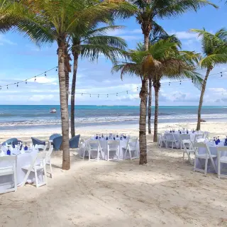 Beach wedding reception setup under palm trees at Catalonia Grand Costa Mujeres, Cancun