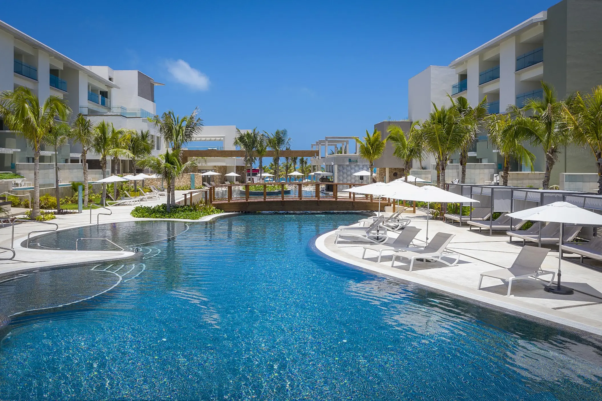 Catalonia Grand Costa Mujeres main pool with lounge chairs and white umbrellas, Cancun