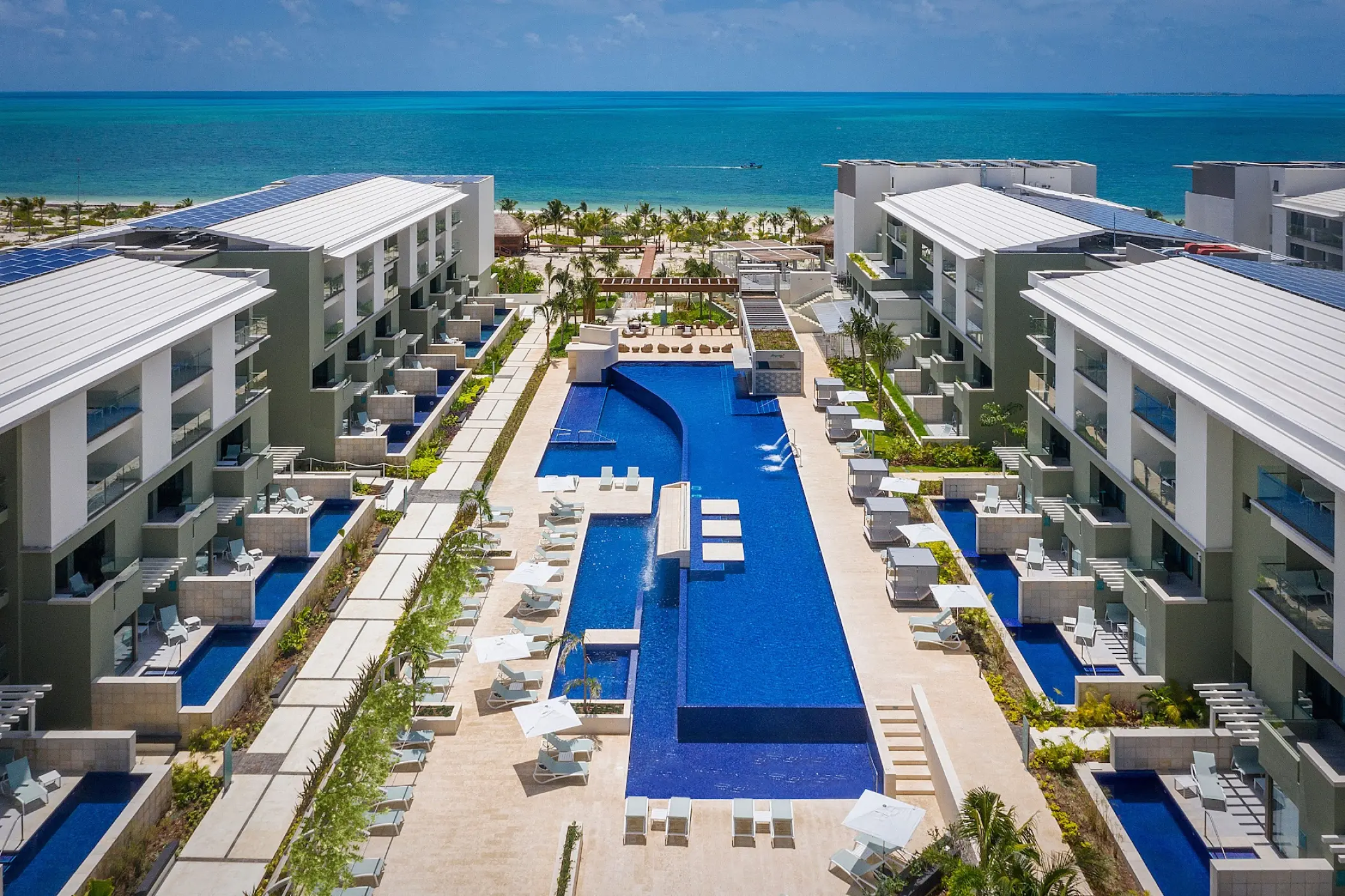 Aerial view of the main swimming pool and modern guest buildings at Catalonia Grand Costa Mujeres, Cancun