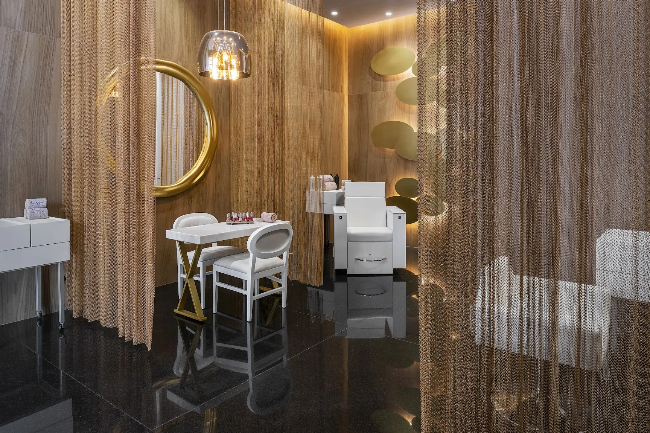 Spa salon with gold chain curtains and white chairs at Catalonia Grand Costa Mujeres, Cancun