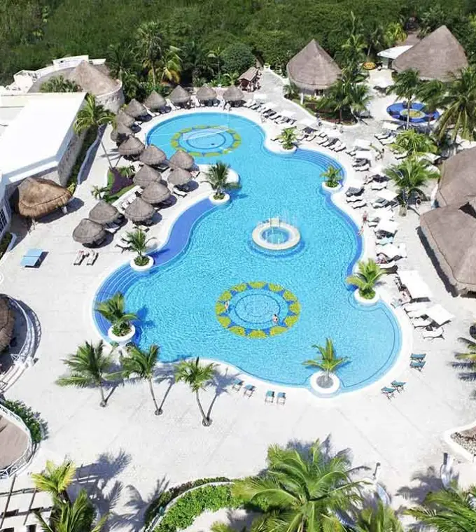 Aerial view of the swimming pool complex surrounded by tropical trees at Catalonia Royal Tulum, Tulum