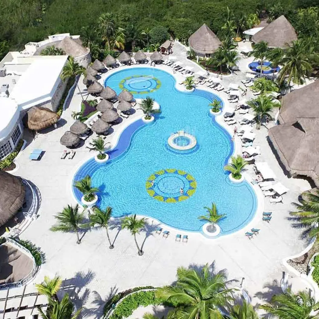 Aerial view of the swimming pool complex surrounded by tropical trees at Catalonia Royal Tulum, Tulum