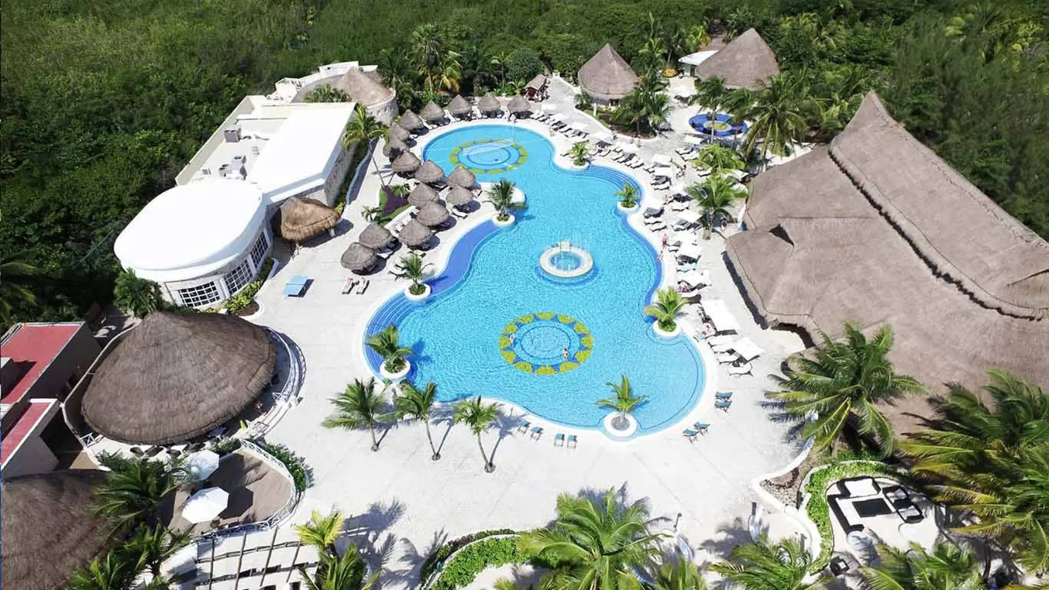 Aerial view of the swimming pool complex surrounded by tropical trees at Catalonia Royal Tulum, Tulum