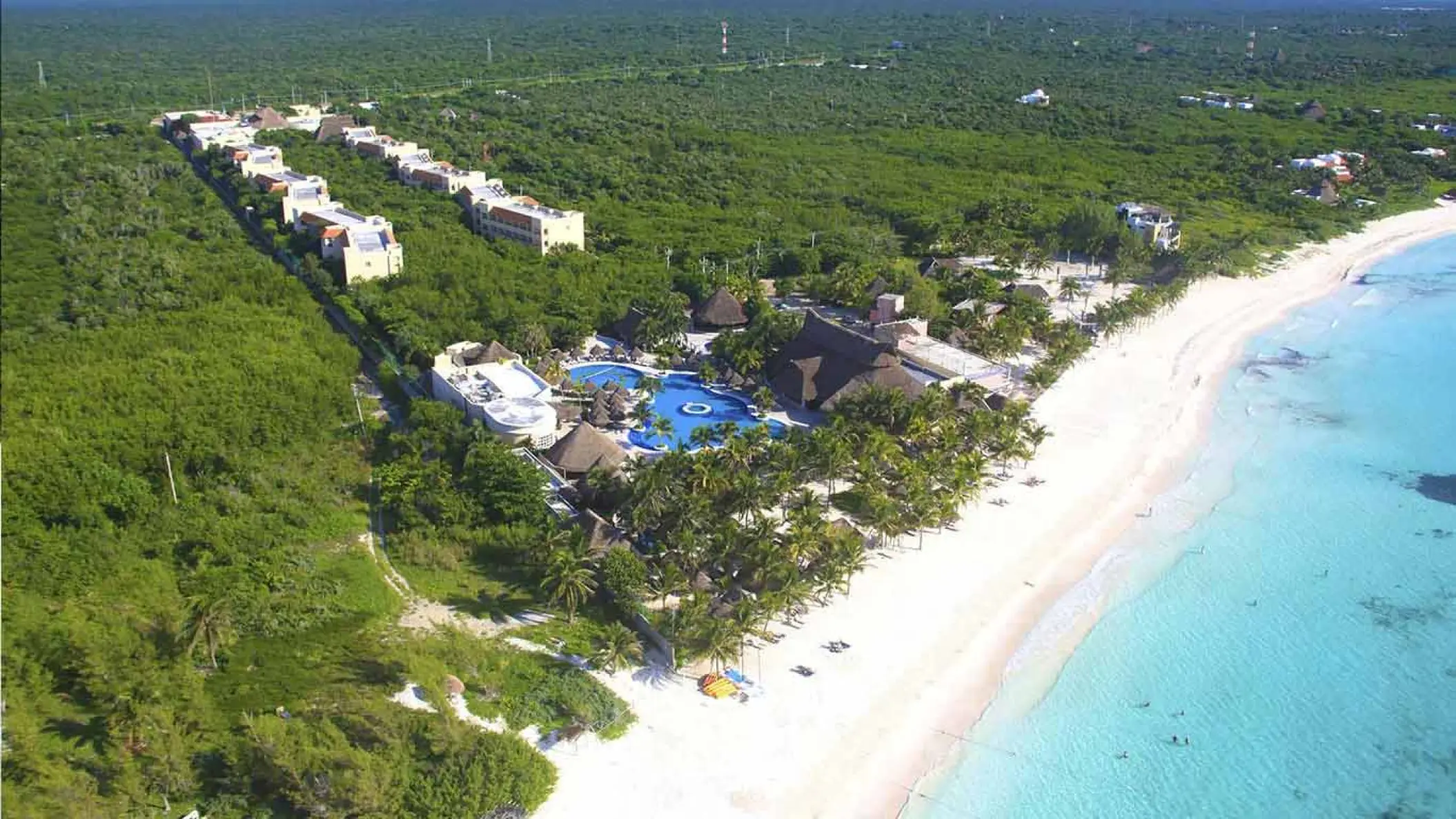 Aerial view of Catalonia Royal Tulum resort buildings nestled in tropical jungle by the beach, Tulum