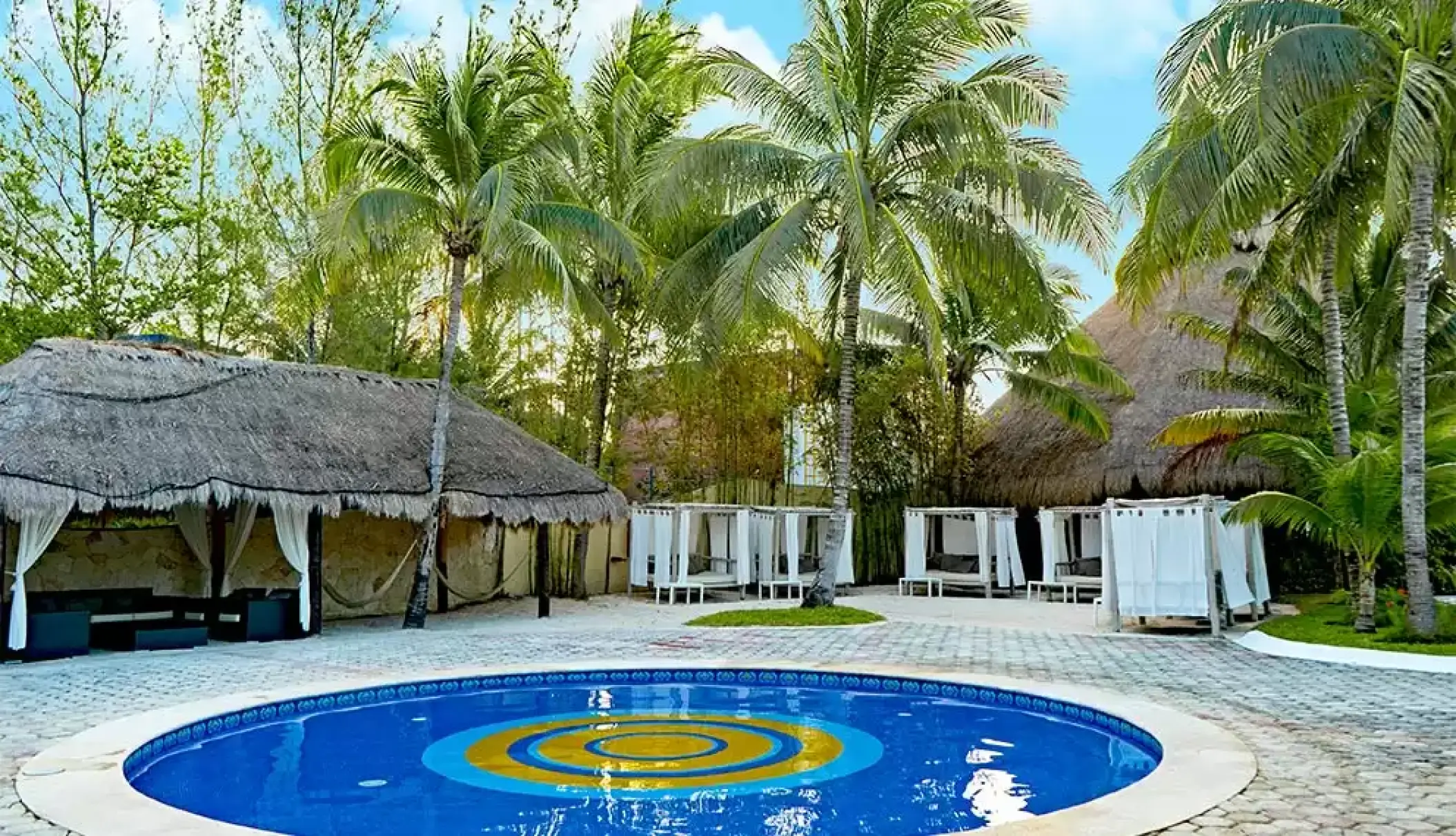 Circular pool and white Balinese beds at Catalonia Royal Tulum