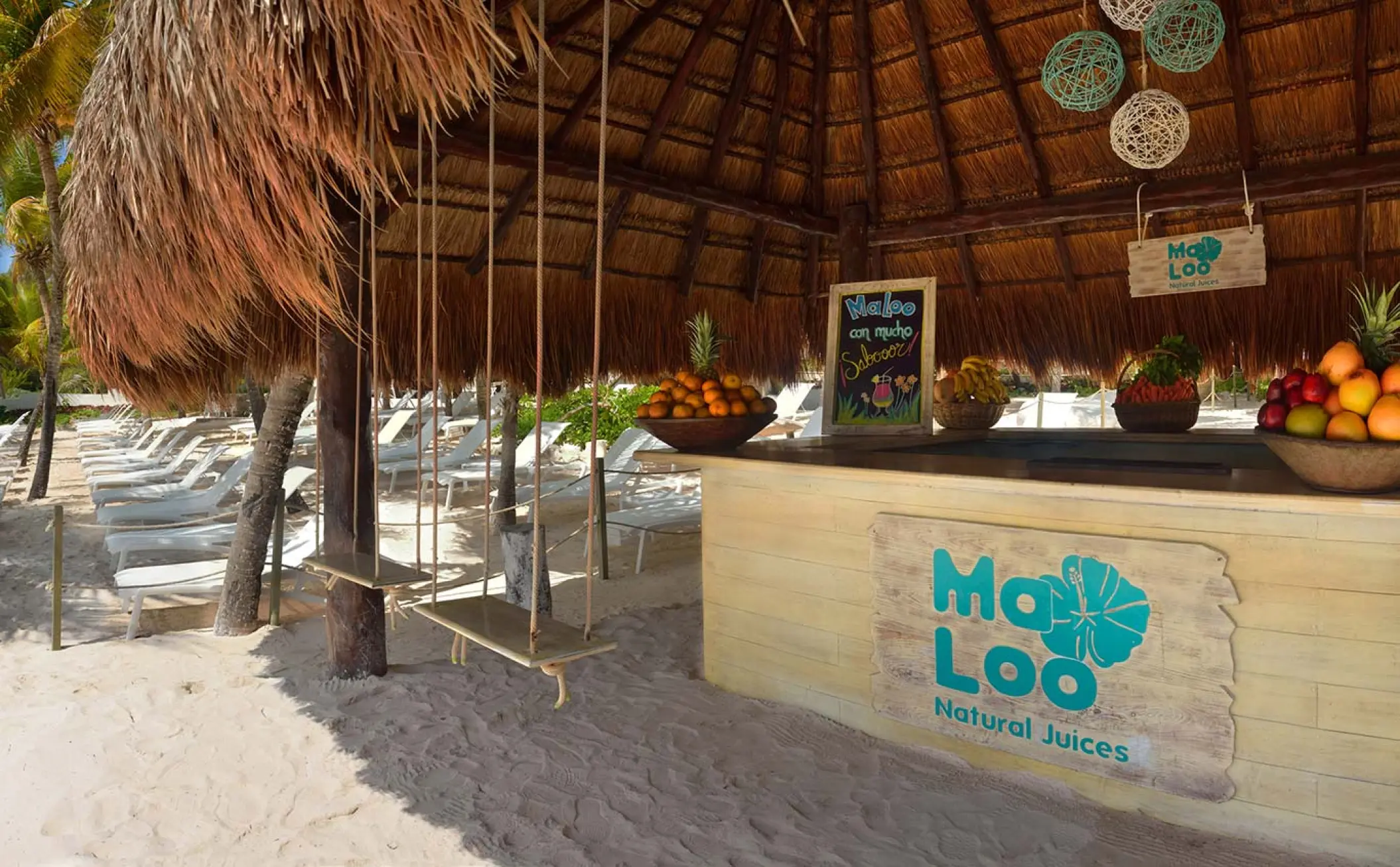Ma Loo juice bar with wooden swing seats under a palapa at Catalonia Royal Tulum, Tulum