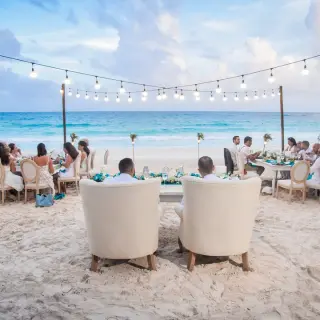 Beachfront wedding reception dinner with string lights at Catalonia Royal Tulum, Tulum