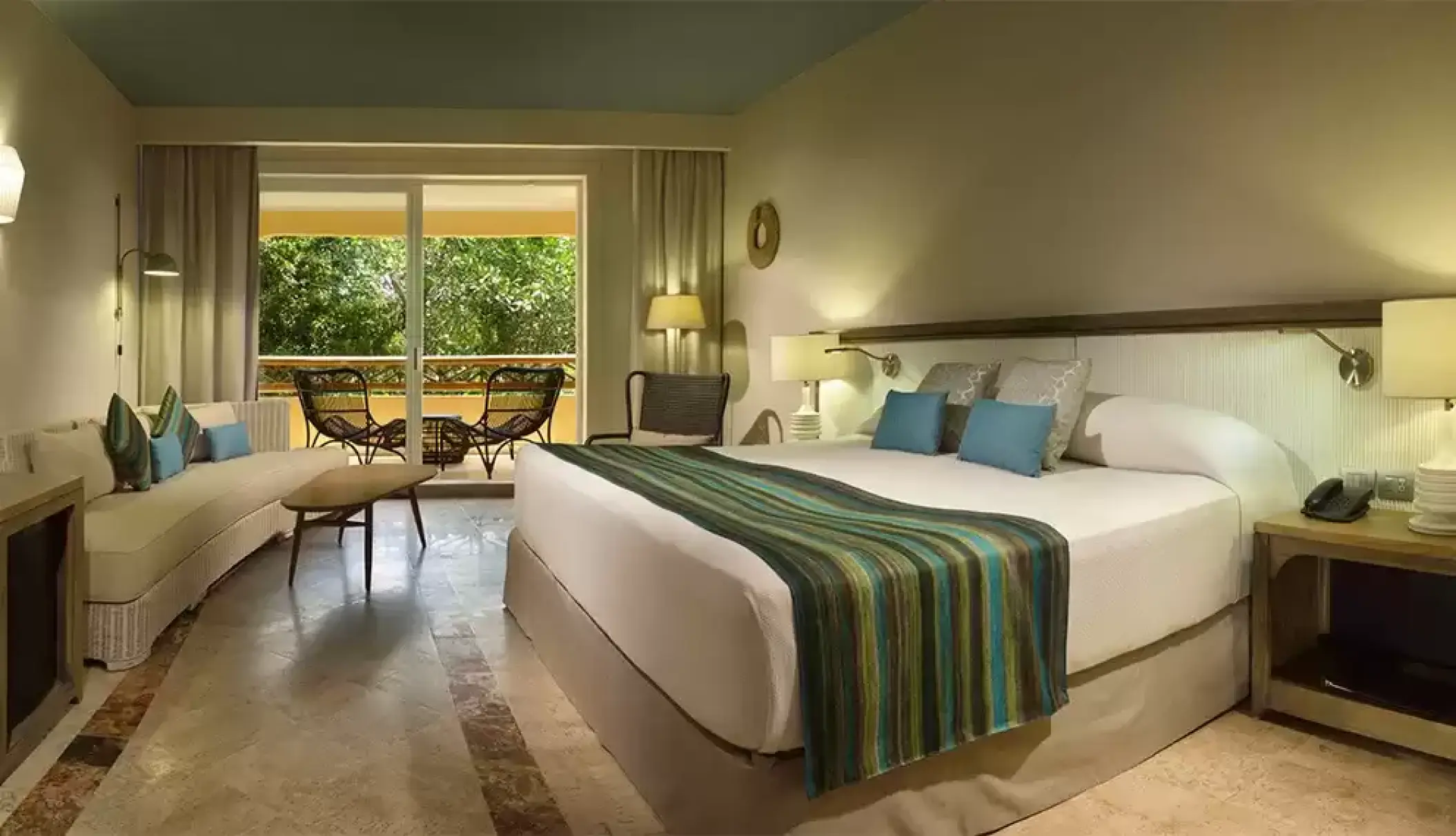 Premium suite with a balcony overlooking tropical greenery at Catalonia Royal Tulum