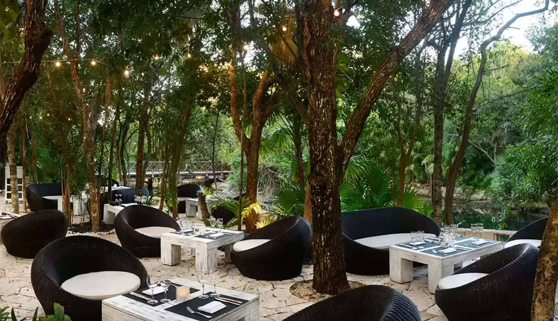 Tapas lounge with wicker seating and string lights at Catalonia Royal Tulum, Tulum