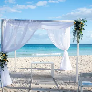 Beachfront wedding ceremony with a white fabric gazebo at Catalonia Royal Tulum, Tulum