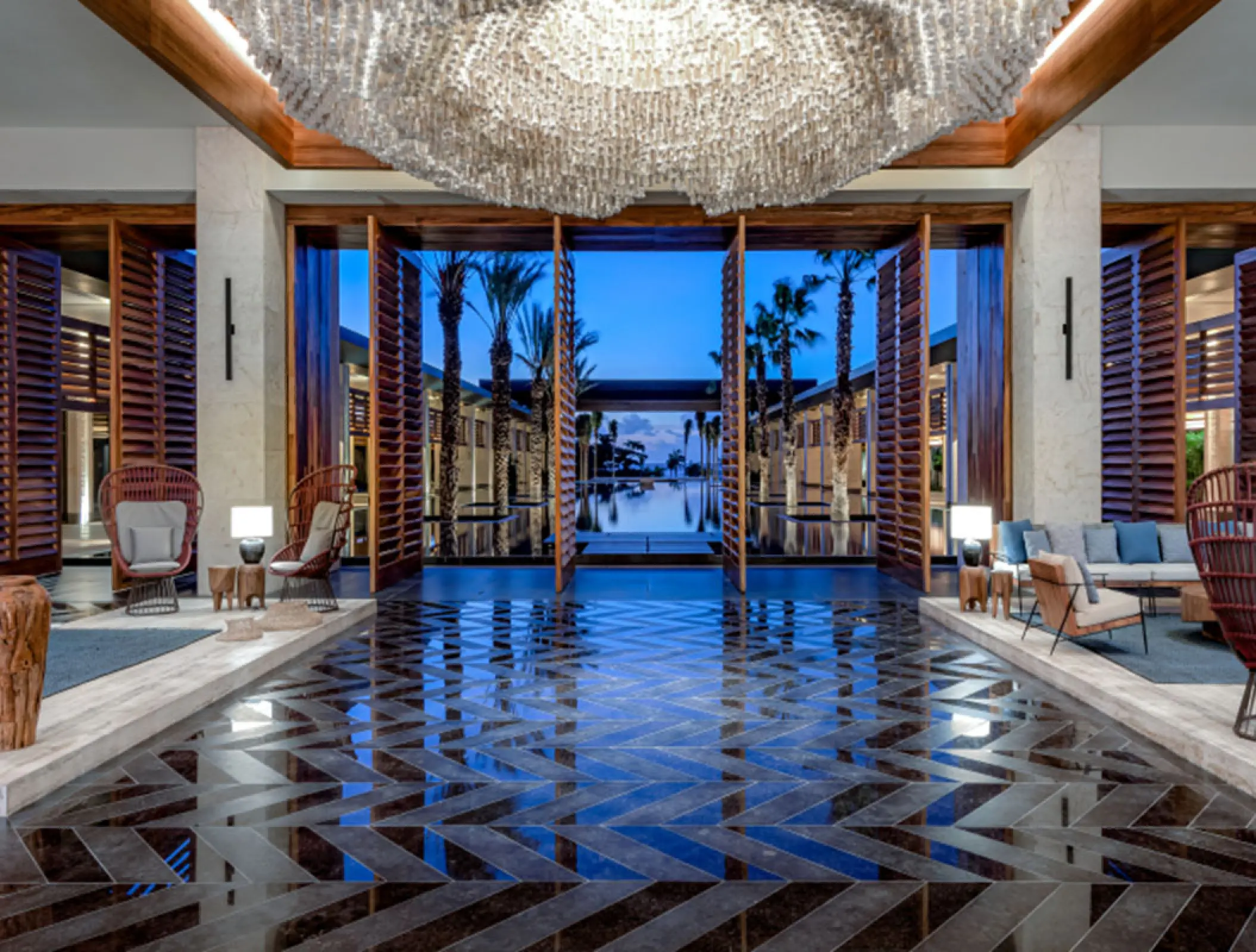 Lobby lounge with tiled floors and view of the central pool at Conrad Tulum, Tulum