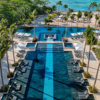 Aerial view of the tiered main pool and sun loungers at Conrad Tulum, Riviera Maya