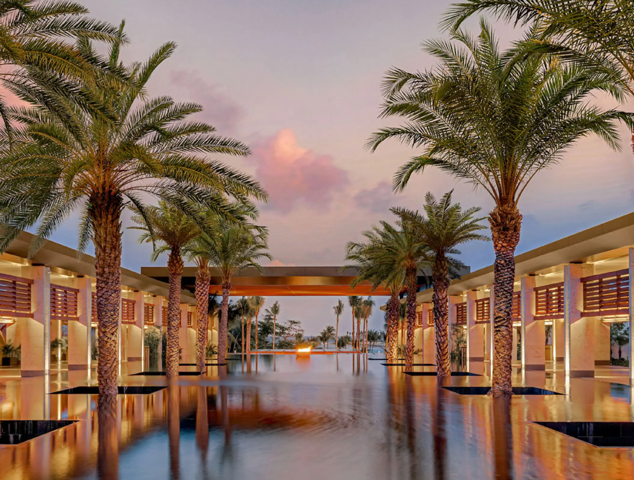 Palm trees standing in a reflection pool at Conrad Tulum, Tulum