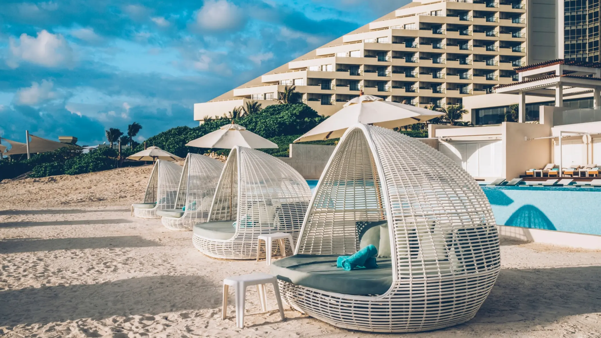 White wicker daybeds on the sand at Coral Level at Iberostar Selection Cancun