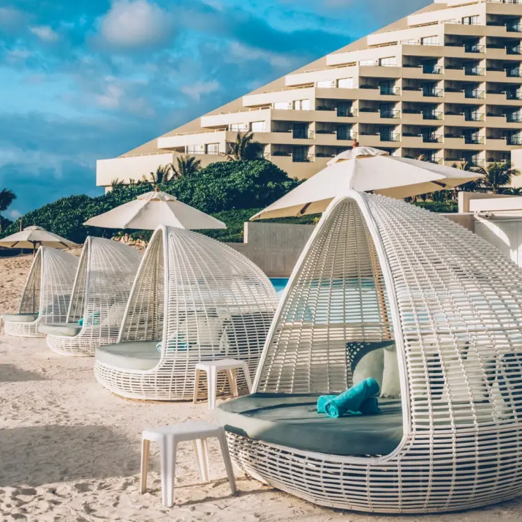 White wicker daybeds on the sand at Coral Level at Iberostar Selection Cancun