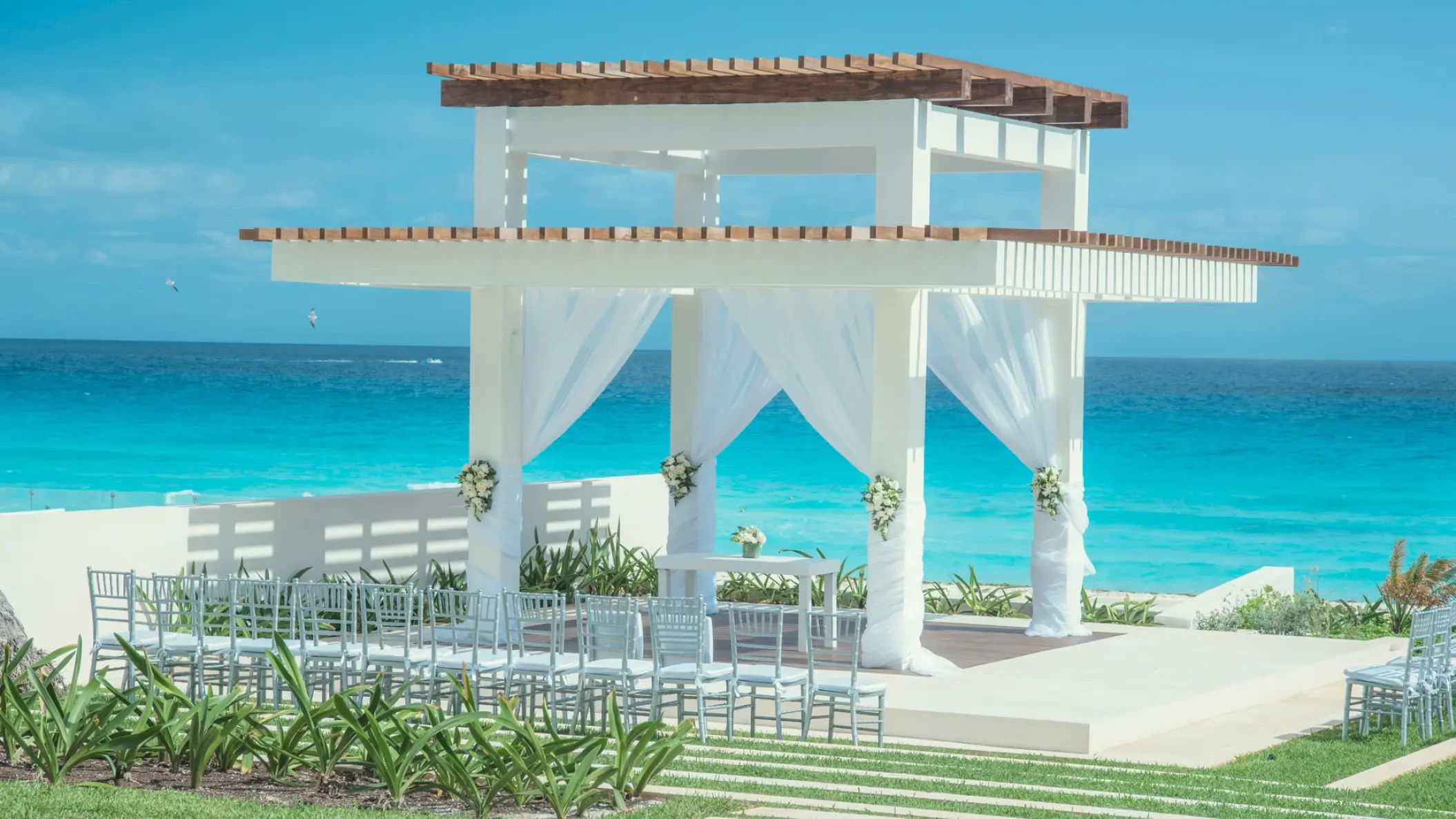 Beachfront wedding ceremony gazebo with white draping at Coral Level at Iberostar Selection Cancun