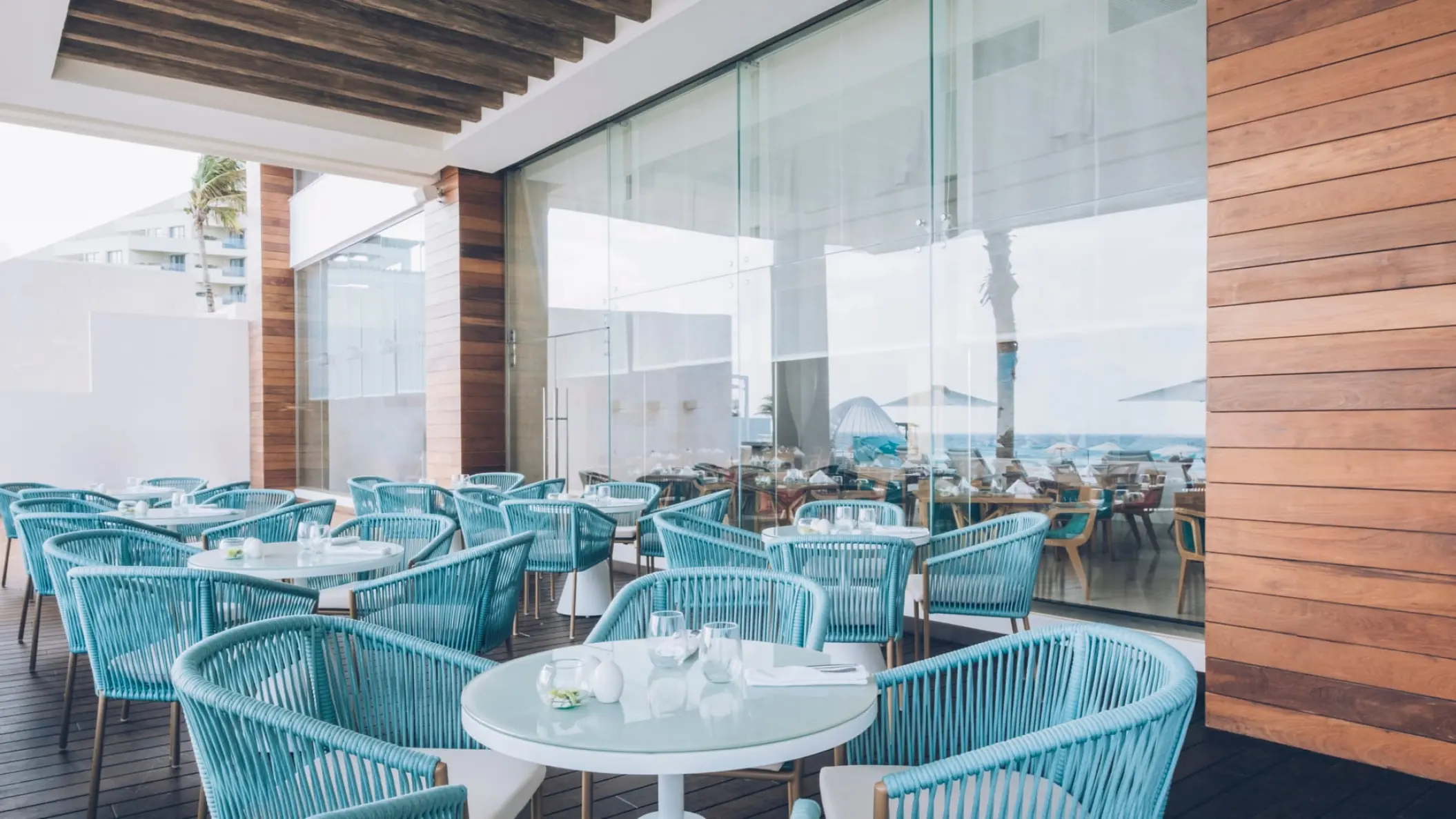 Outdoor restaurant with blue woven chairs at Coral Level at Iberostar Selection Cancun