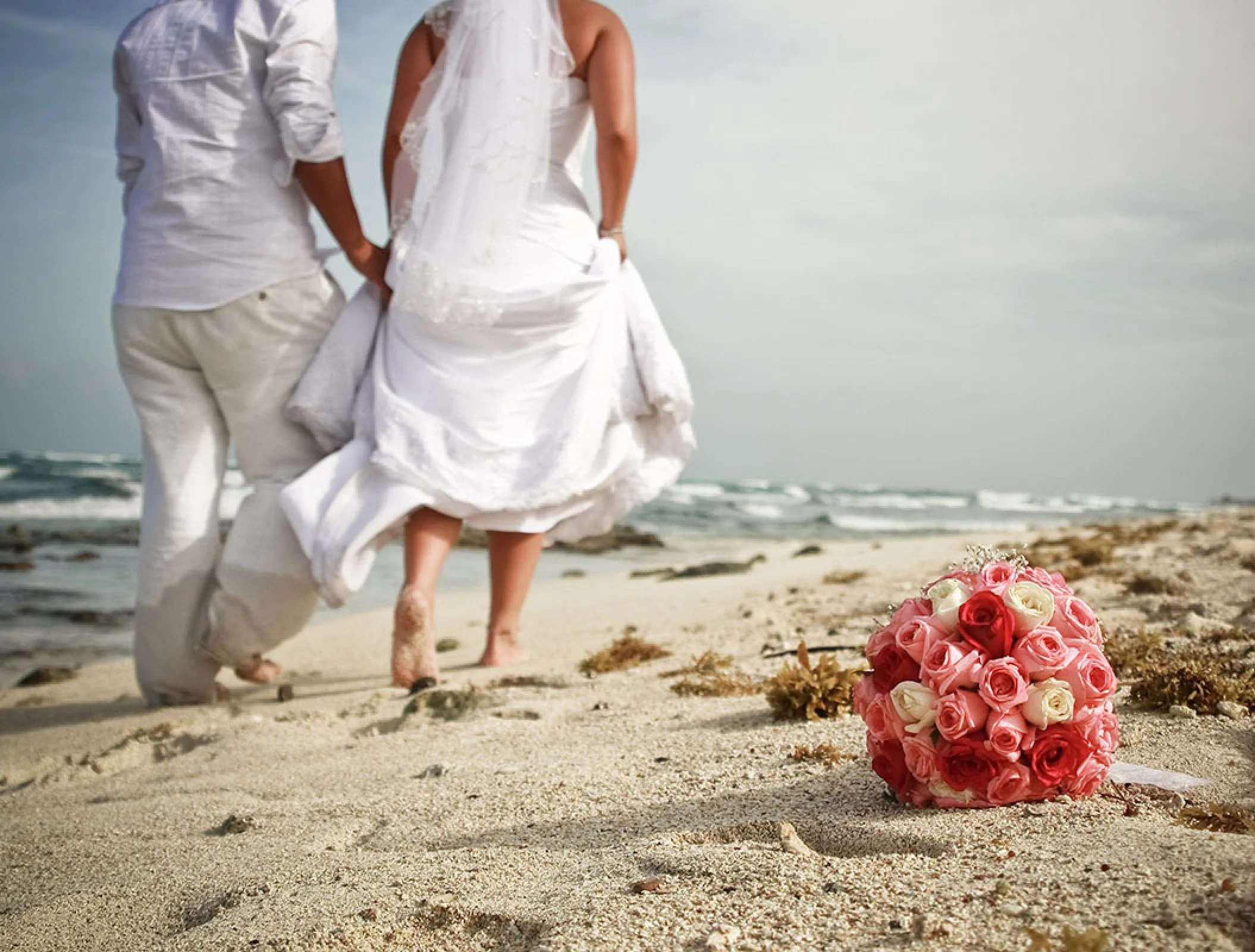 Just married Couple walking away at the beach.