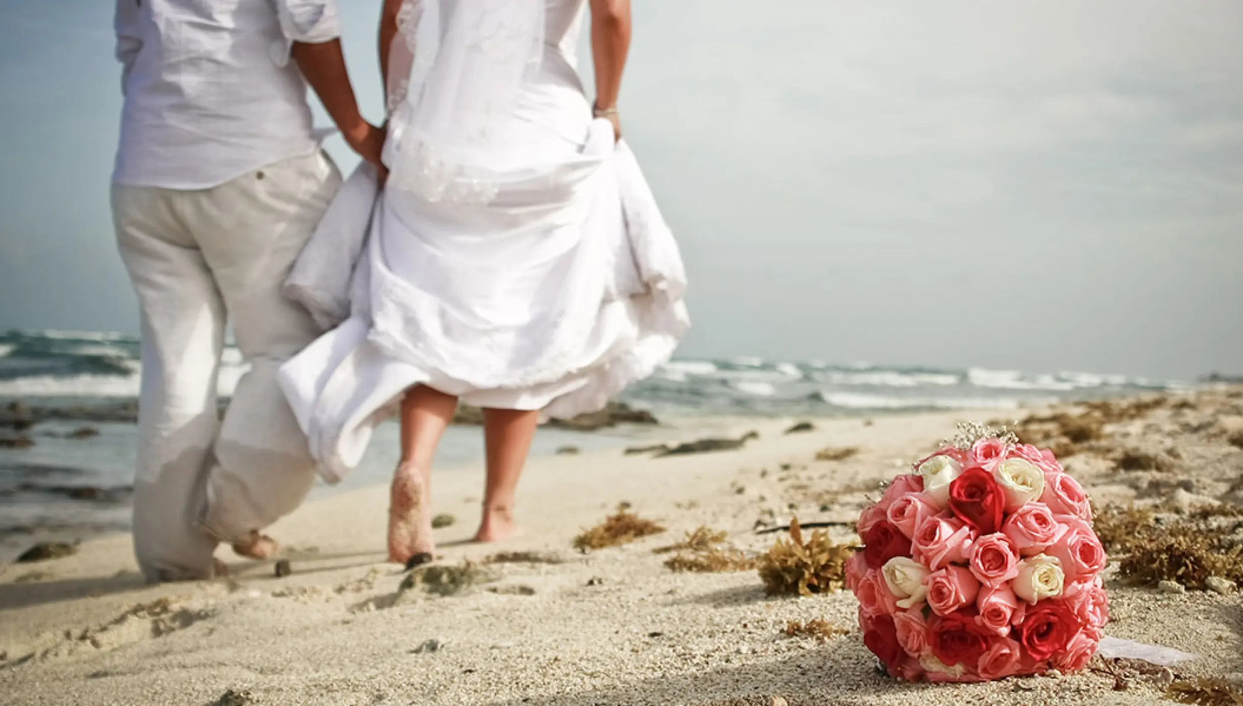Just married Couple walking away at the beach.